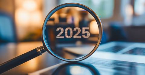 Vergrootglas op een bureau waarop 2025 te zien is